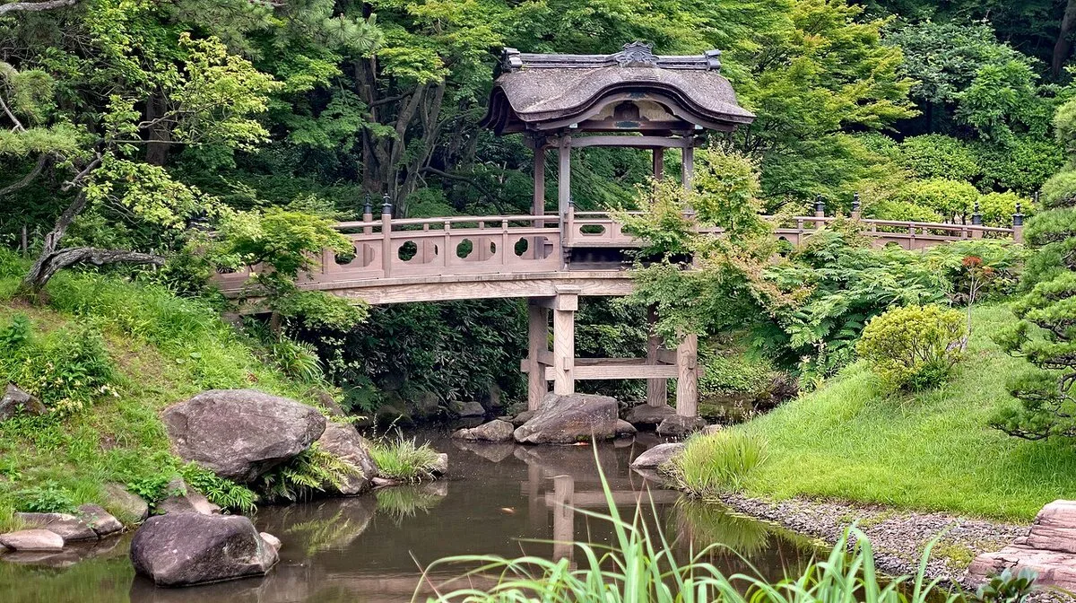 Covered wooden bridge over a pond at Sankei-en Japanese garden in Yokohama